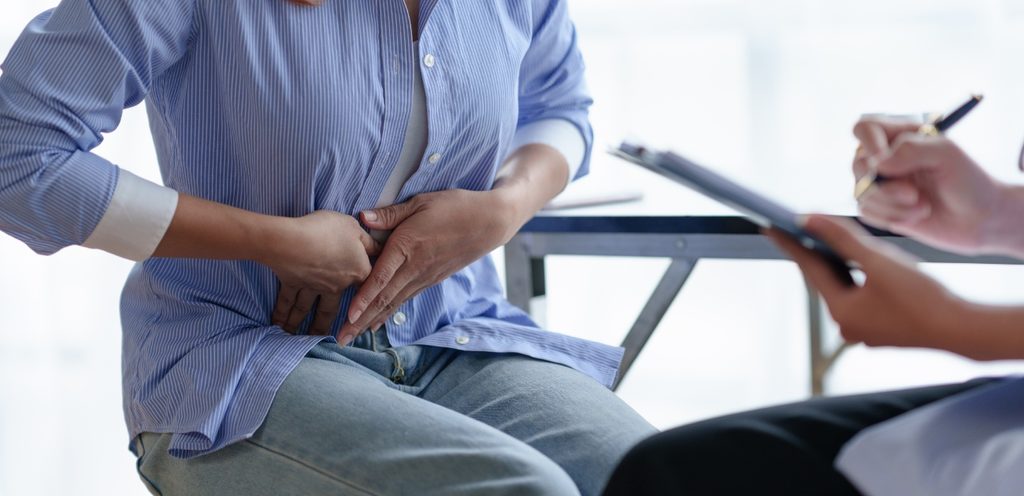 امرأة تُعاني من آلام البطن وتزور الطبيب