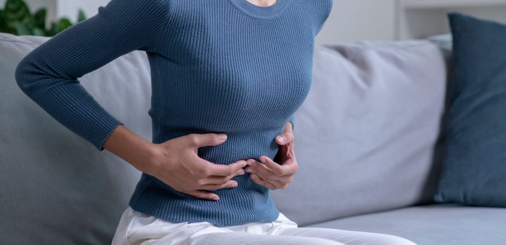 امرأة تضع يديها على بطنها