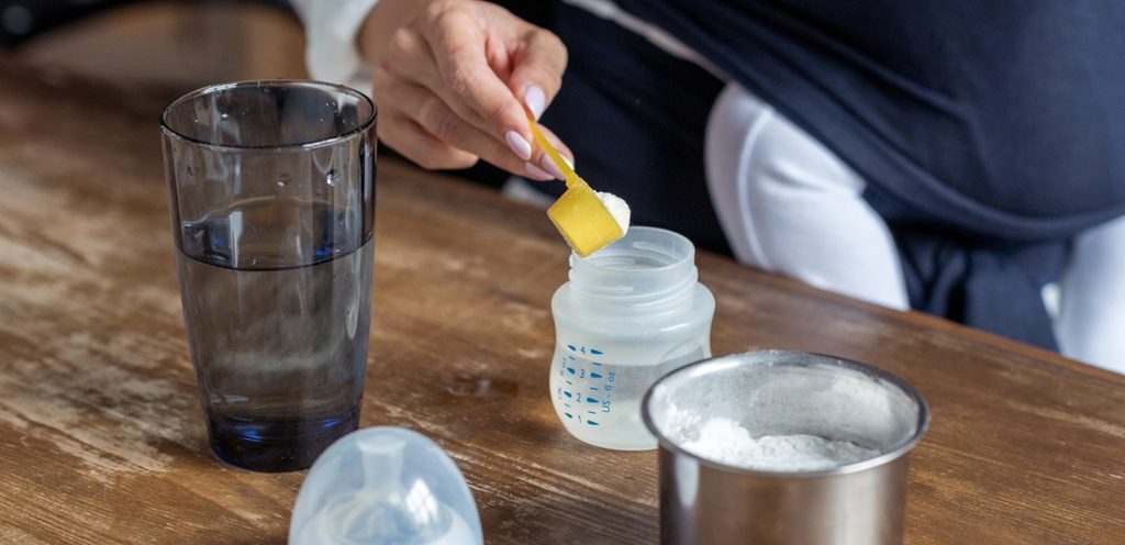 يد امرأة تُحضّر الحليب الصناعي الخاص بالأطفال