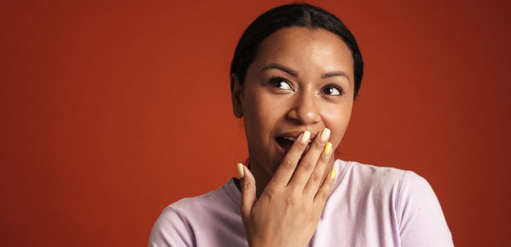 امرأة تضع يدها أمام فمها وتنظر لأعلى