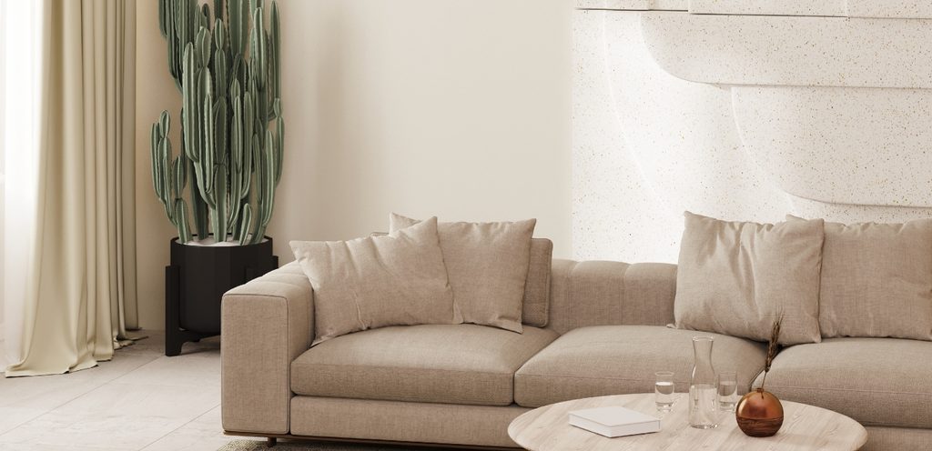 كنبة وطاولة بيج وخلفهما نبتة صبّار