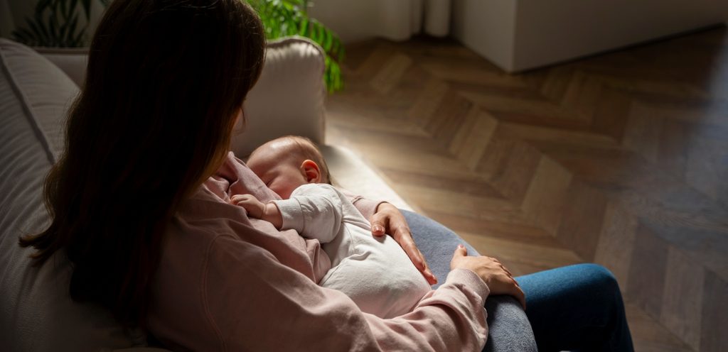 لقطة خلفيّة لأمّ تُرضع طفلها