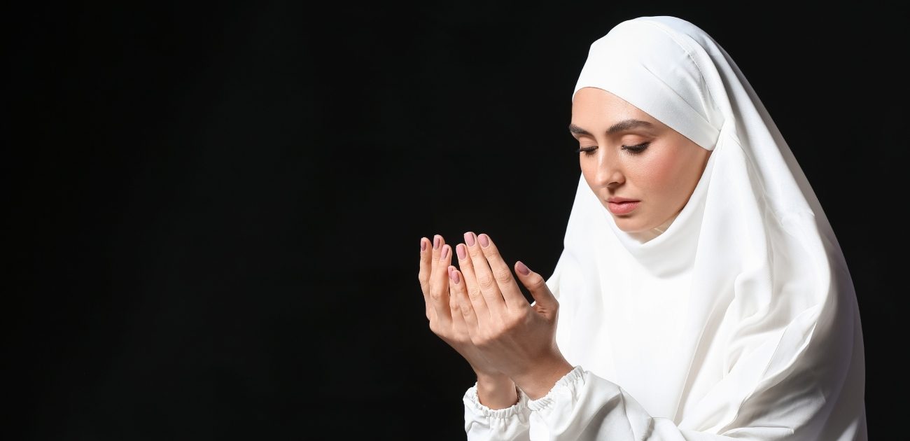 امرأة مسلمة تمدّ يديها للدعاء