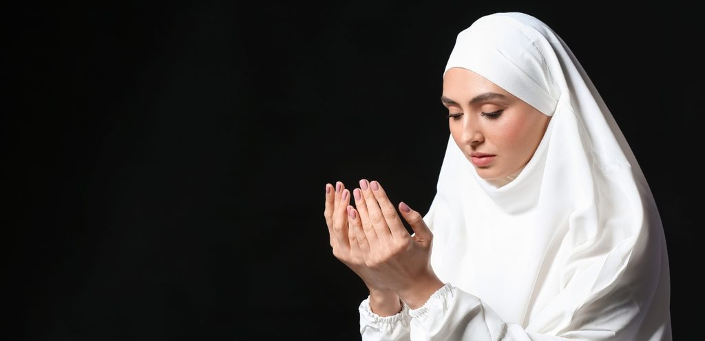 امرأة مسلمة تمدّ يديها للدعاء