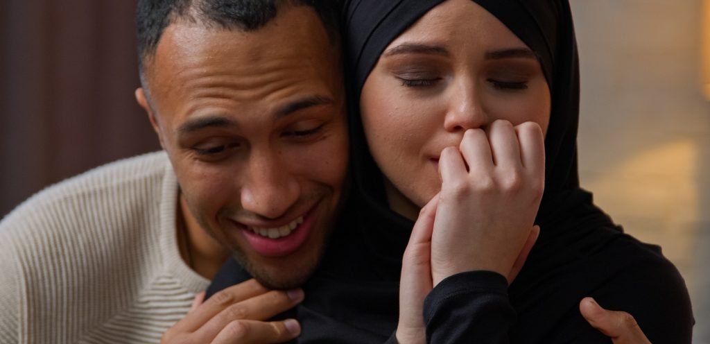 زوج يُعانق زوجته بسعادة