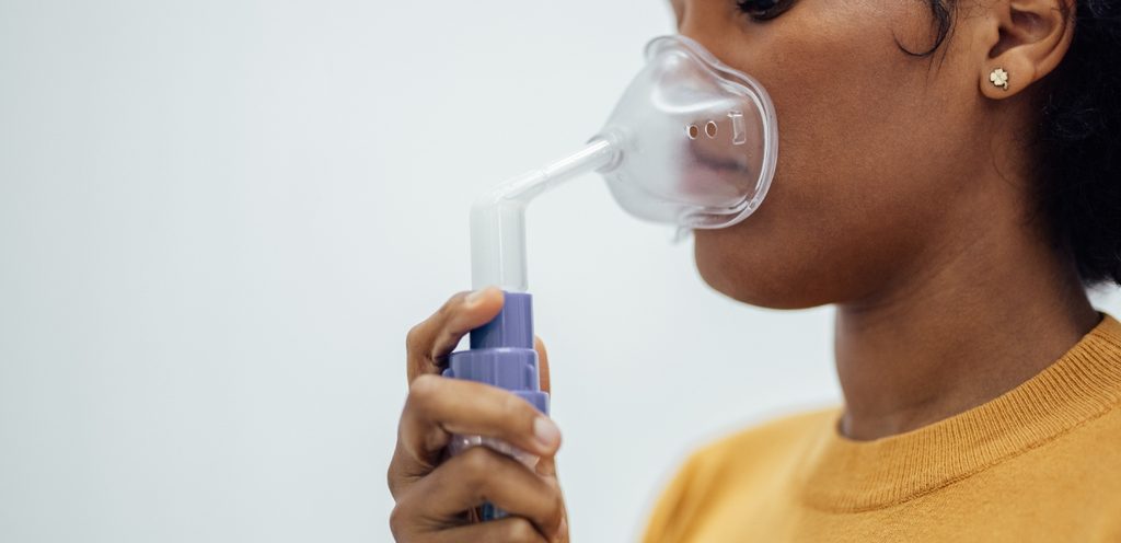 امرأة تستخدم قناع الأكسجين