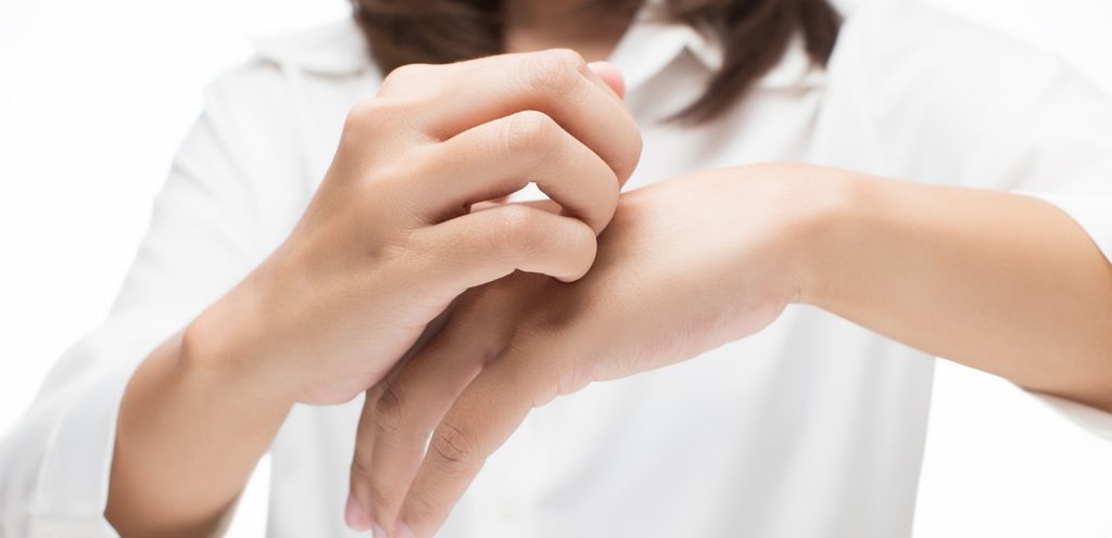 امرأة تحكّ يدها باليد الأخرى