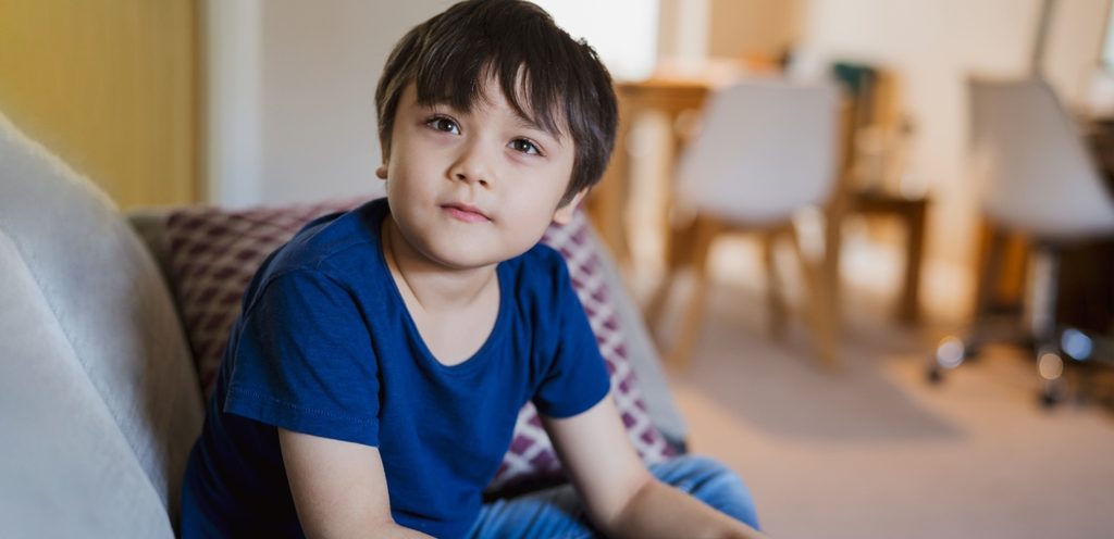 طفل يجلس على الكنبة في المنزل