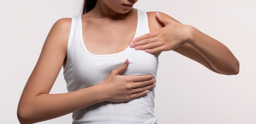 امرأة تضغط بيديها على ثديها