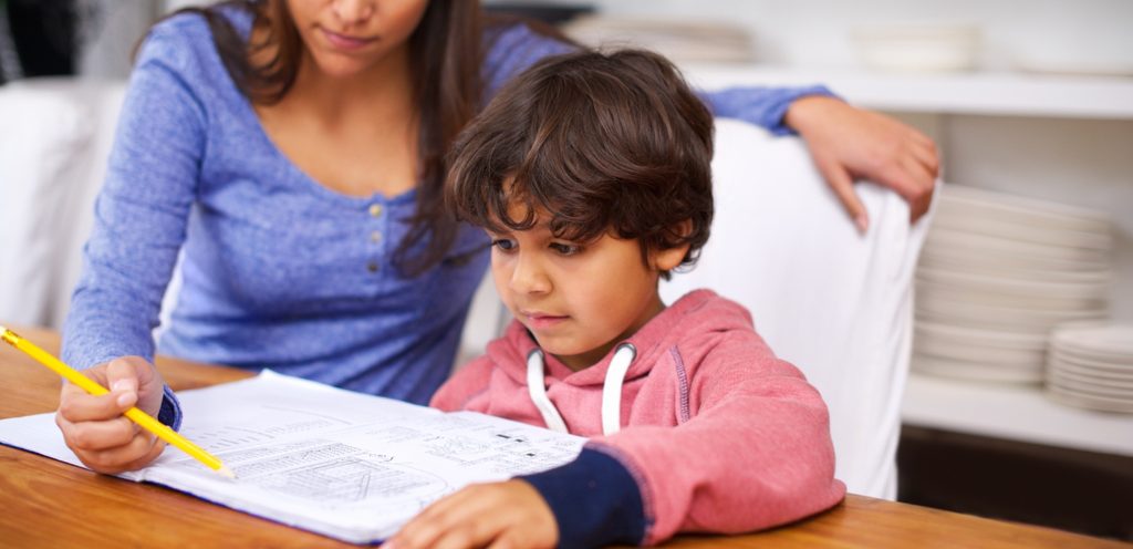 أمّ تُساعد طفلها في حلّ واجباته المدرسيّة