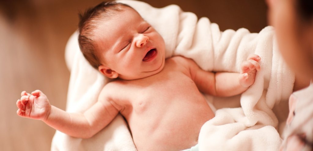 طفل حديث الولادة تحمله والدته