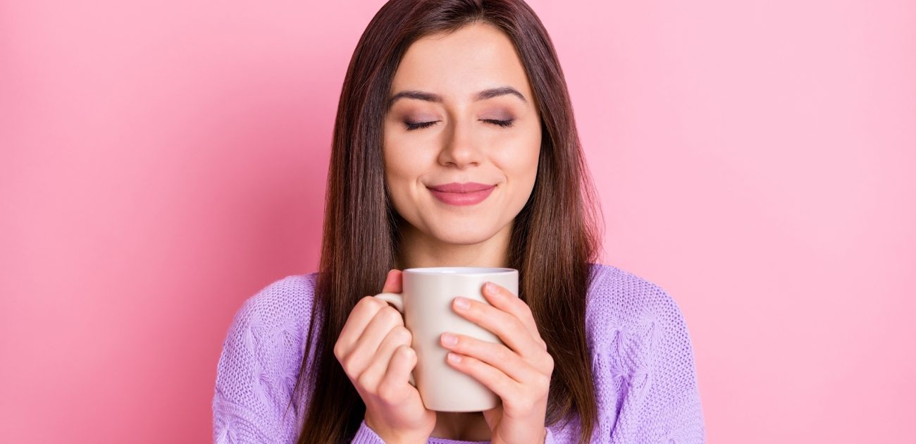 امرأة سعيدة تُمسك كوب من الشاي