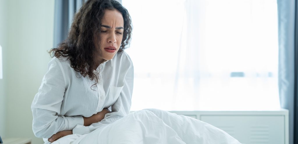 امرأة في سريرها تُعاني من آلام البطن