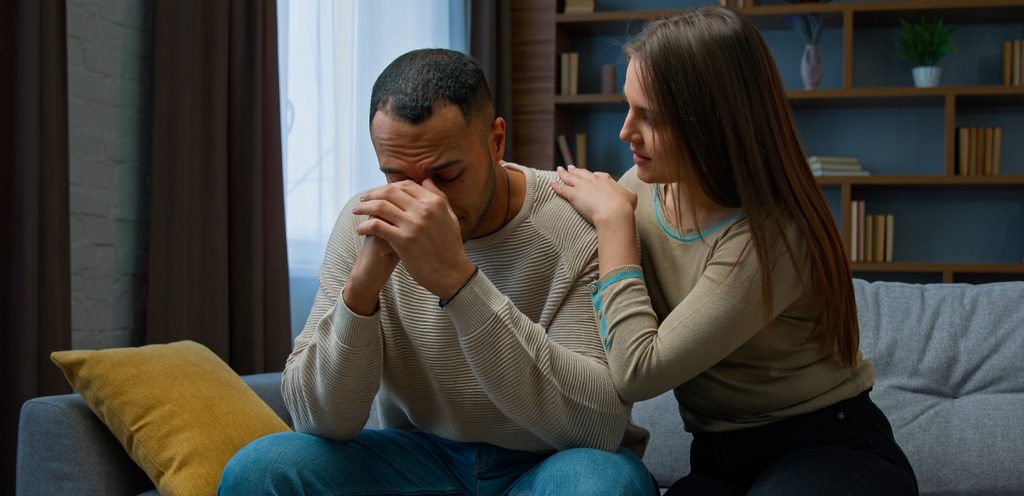 رجل حزين وزوجته تُحاول مواساته
