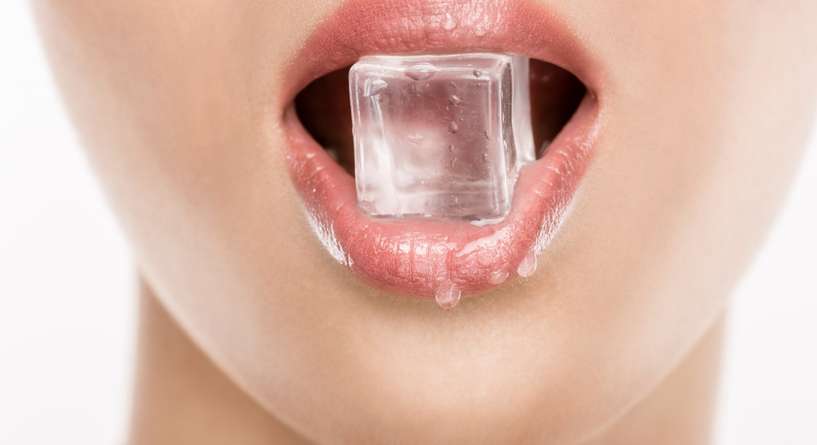 امرأة تأكل قطعة من الثلج