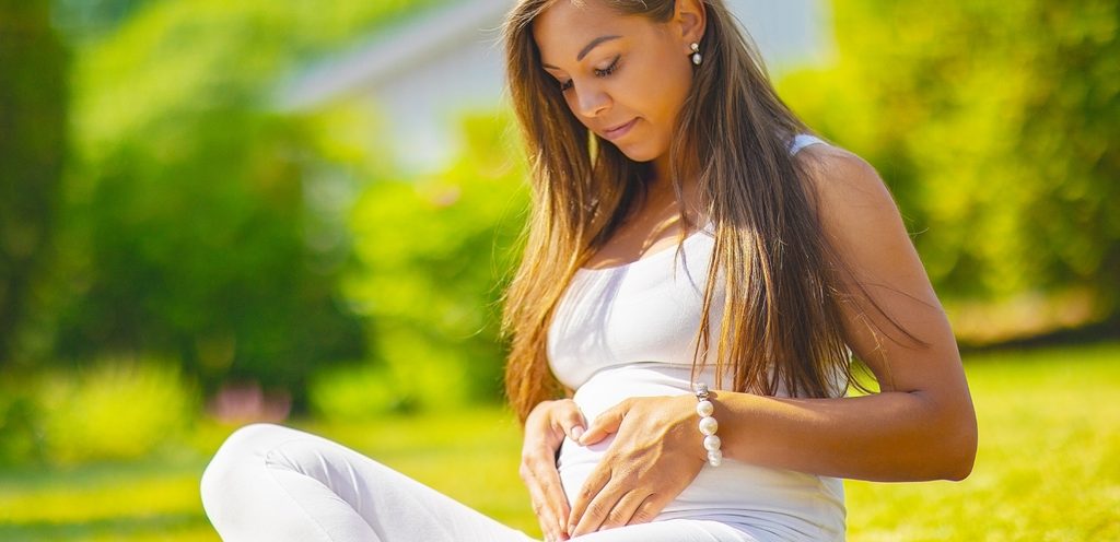 سيدة حامل تنظر إلى بطنها