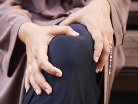 سيدة تعاني من ألم في الركبة