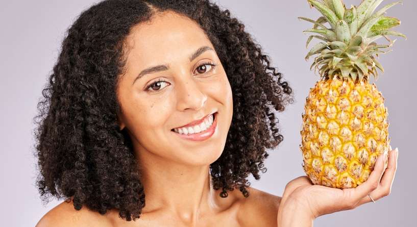 امرأة تحمل فاكهة الأناناس