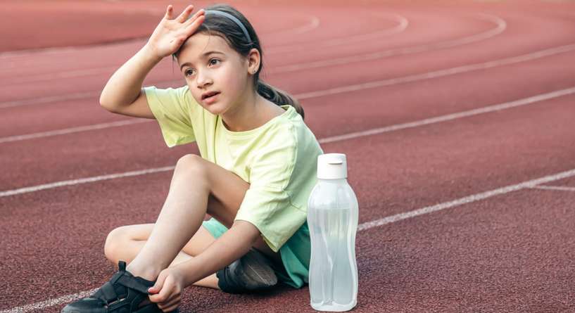 فتاة تجلس على الأرض متعبة من جراء الشمس