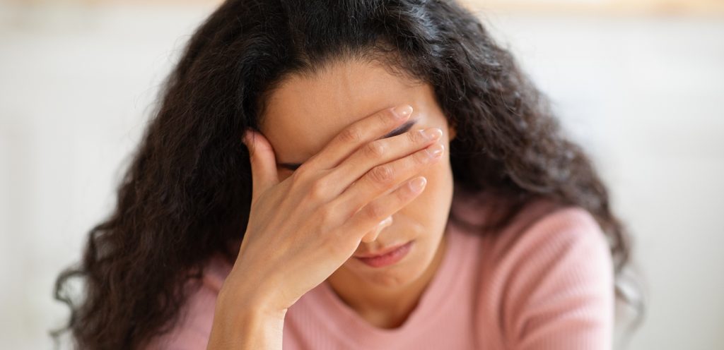 امرأة تضع يدها على جبينها وتنظر إلى أسفل