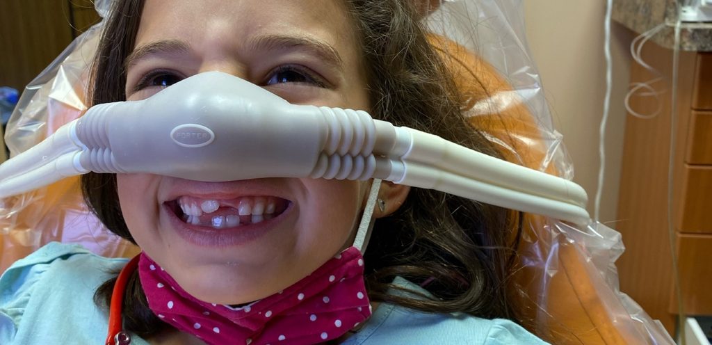 طفلة تضحك وعلى أنفها أنبوب غاز