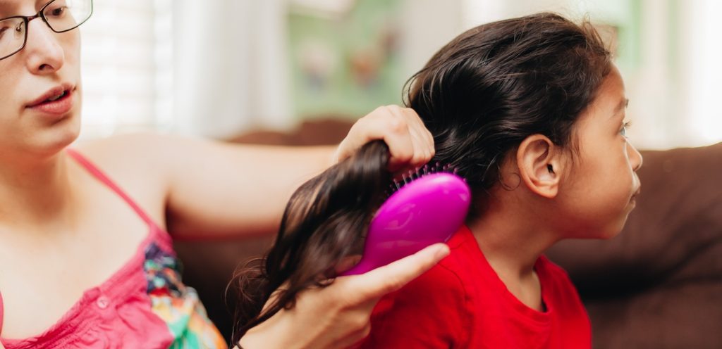 أمّ تمشط شعر ابنتها بالفرشاة