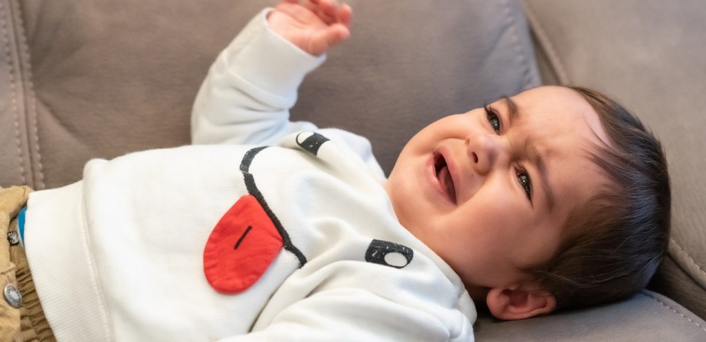 طفل مستلقي على الكنبة يبكي