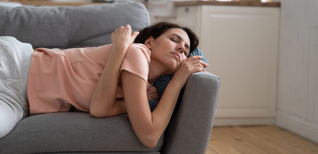 امرأة متعبة نائمة على الكنبة