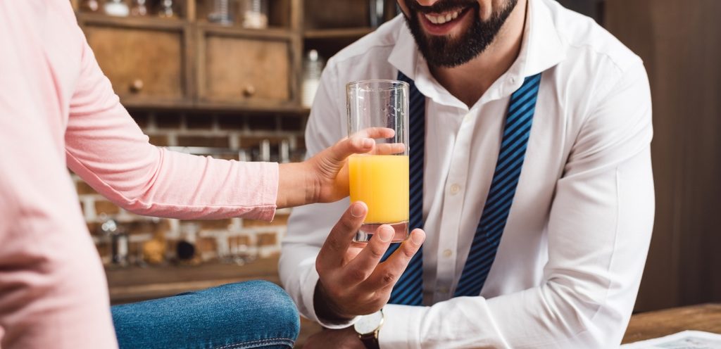 امرأة تُقدّم كوب من العصير إلى زوجها