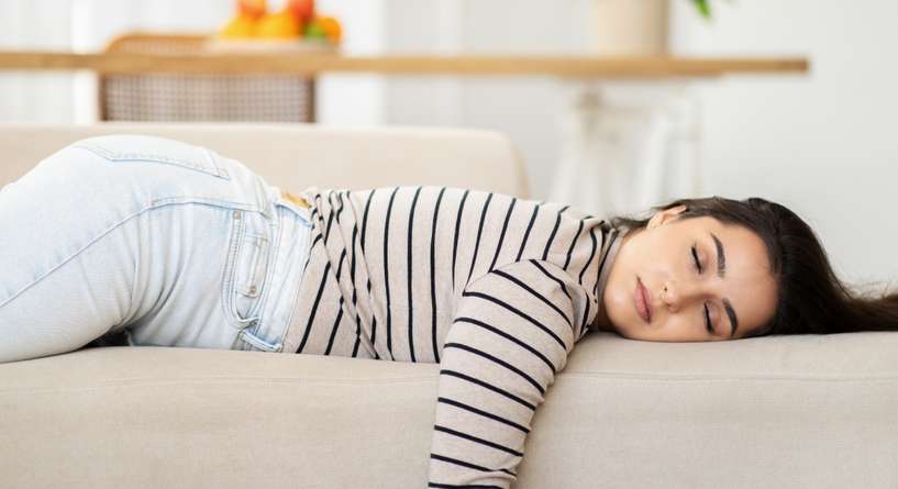 امرأة مُتعبة نائمة على الكنبة
