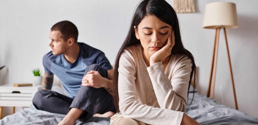 زوجان حزينان يجلسان على السرير