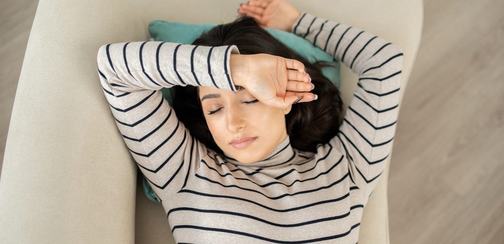 امرأة نائمة تضع يدها على جبينها