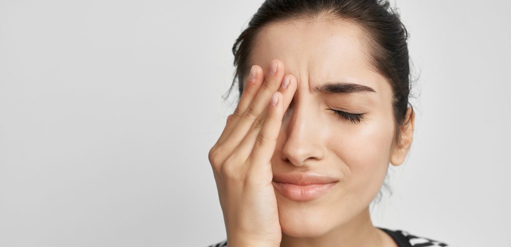 امرأة تشعر بالألم تضع يدها على عينها