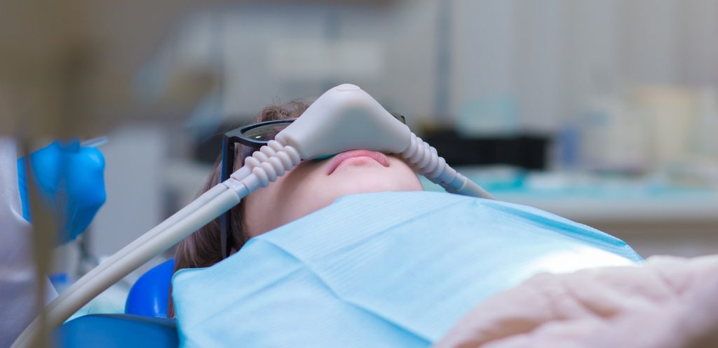 طفل مريض نائم في غرفة العمليّات وعلى أنفه أنبوب غاز