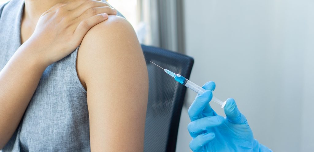 يد طبيب تمسك إبرة لحقن المريضة في ذراعها