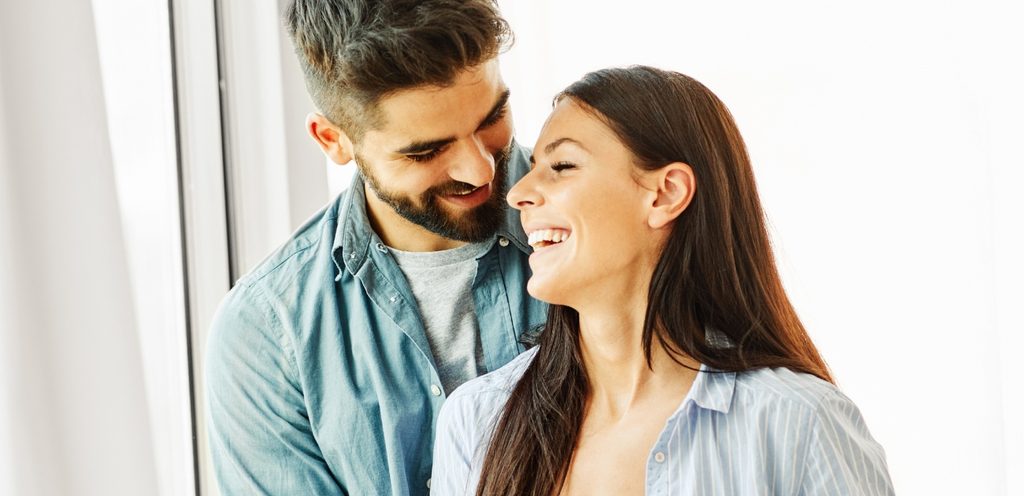 زوجان سعيدان يضحكان وهما قريبين من بعضهما البعض