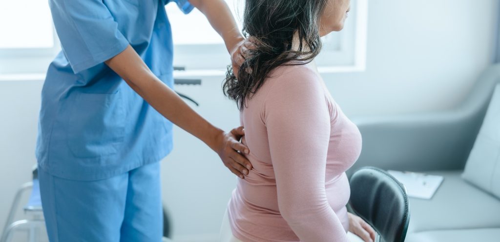 امرأة تُعاني من آلام الظهر تفحصها الطبيبة