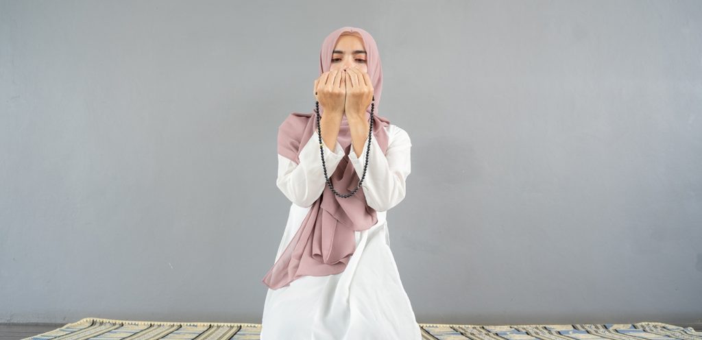 امرأة مسلمة ترفع يديها للدعاء