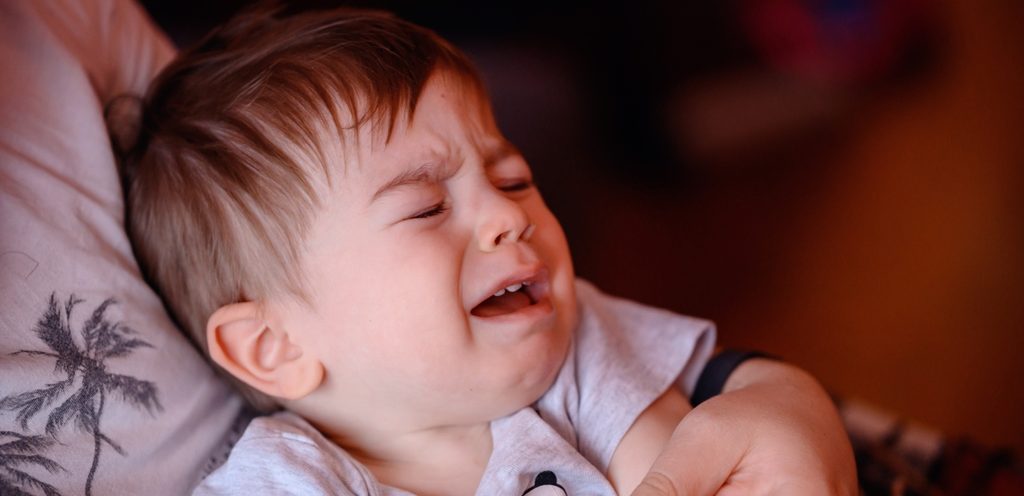 طفل يبكي وهو جالس في حضن شخص