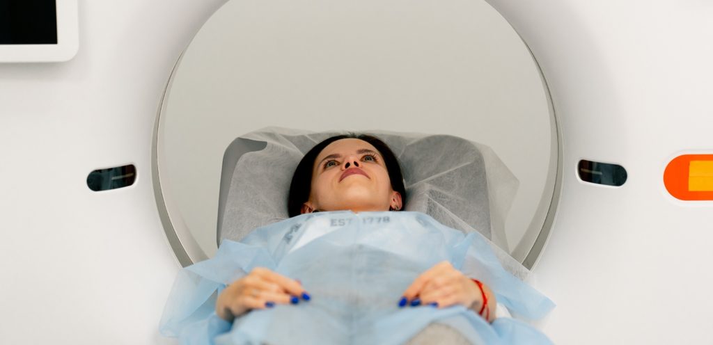 امرأة مستلقية للدخول في آلة الأشعّة المقطعيّة