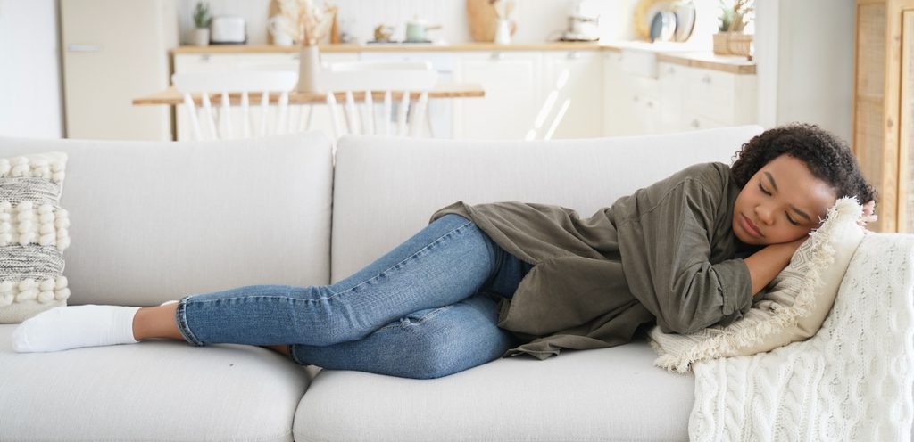 امرأة نائمة على الكنبة في المنزل