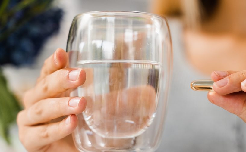حبة من الفيتامين د مع كوب من الماء