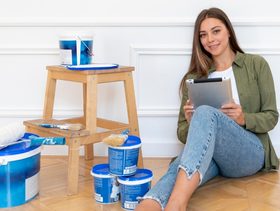 امرأة تقوم بطلاء الصالة