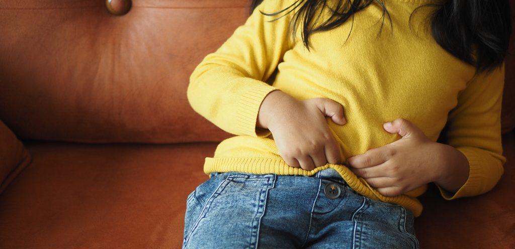 طفلة تضع يديها على بطنها