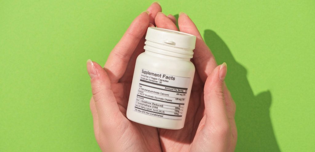 يدي امرأة تمسكان علبة دواء