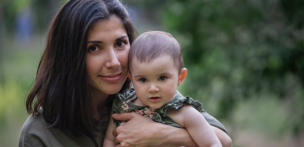 أمّ تحمل طفلتها الرضيعة