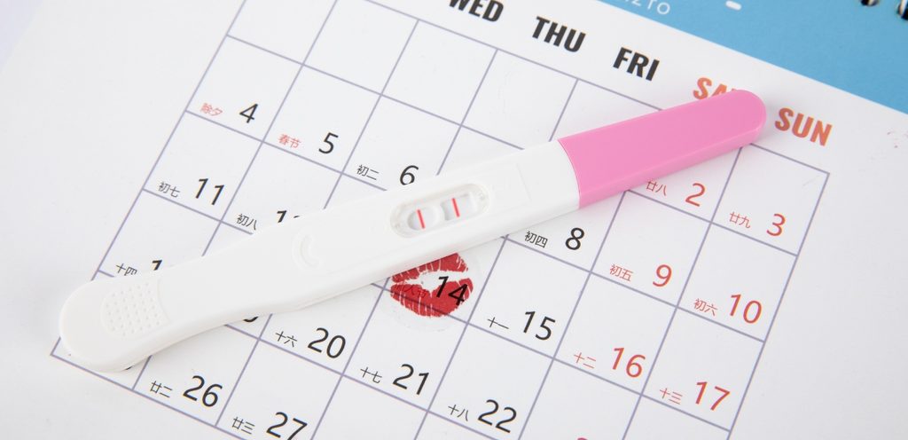 ورقة عليها تواريخ وعلامة حمراء واختبار حمل إيجابي