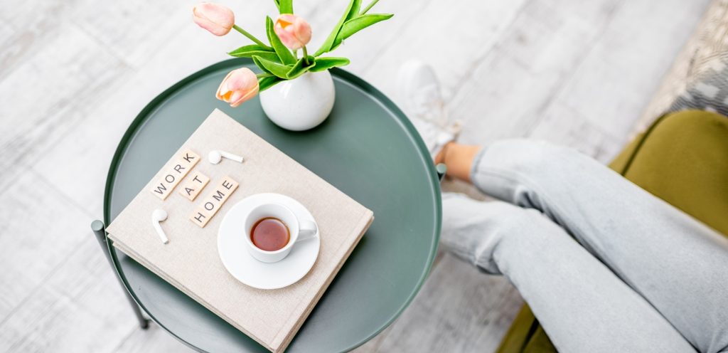 فنجان من القهوة على طاولة عليها ورود وأحرف وسماعات