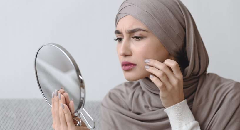 امرأة تنظر في مرآتها