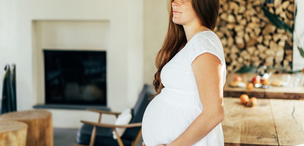 امرأة حامل تقف في المنزل